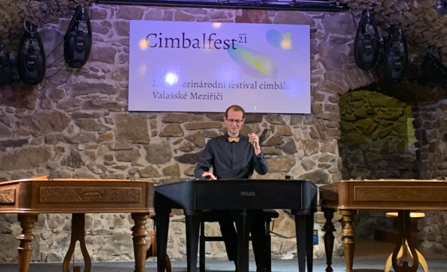 Male student on stage playing the cimbalom