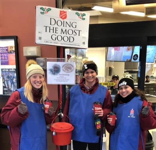 NSU student-athletes standing by Salvation Army Red Kettle
