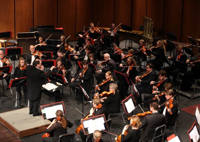 Conductor directing the Aberdeen University-Civic Symphony on stage