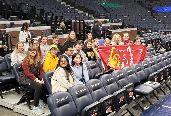 NSU TRIO students sitting in a stadium holding a Northern Wolf flag